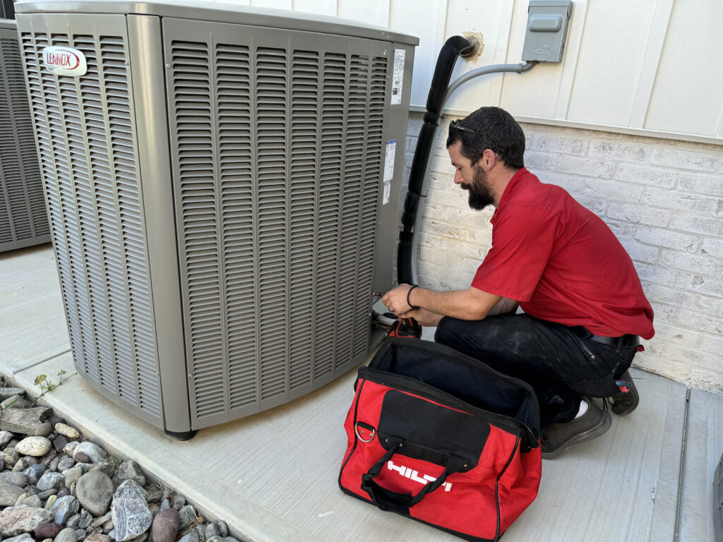 Big Red Plumbing expert repairing water heater system in utility room